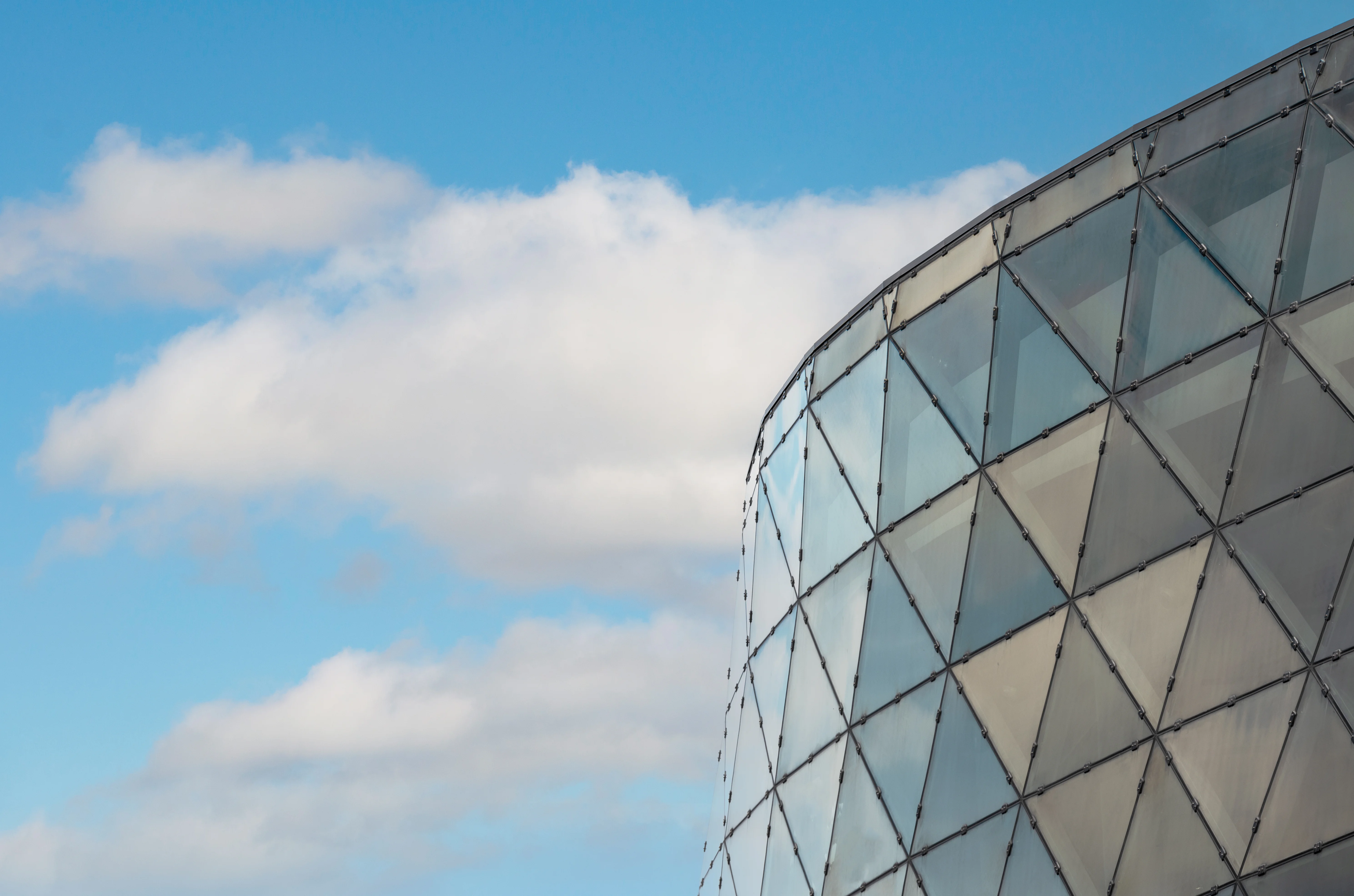 Ottawa's Shaw Centre convention centre with its iconic geodesic glass dome photographed from across the Rideau Canal, boats moored in the foreground under a partly cloudy sky